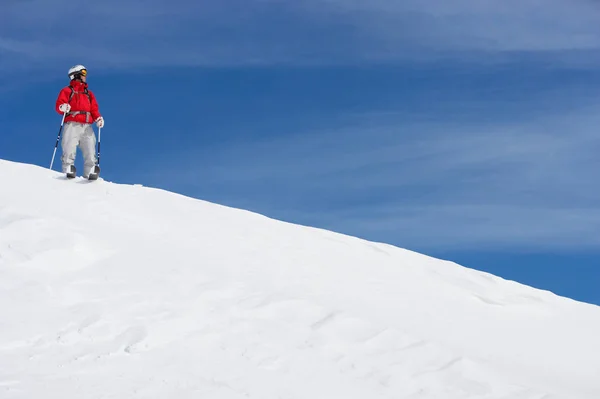 Mężczyzna narciarz stojąc na zaśnieżonym stoku — Zdjęcie stockowe