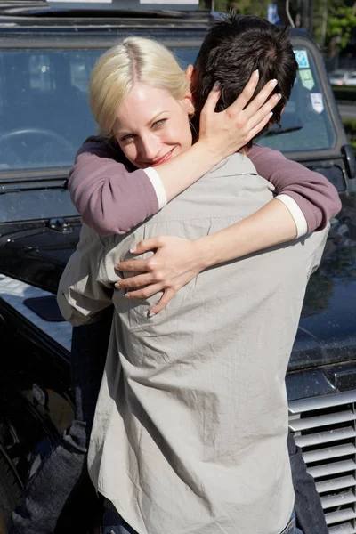 Casal abraçando enquanto em pé de carro — Fotografia de Stock
