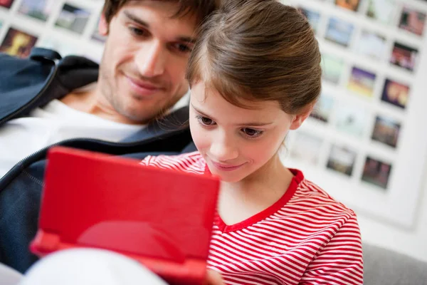 Chica jugando videojuego papá viendo — Foto de Stock