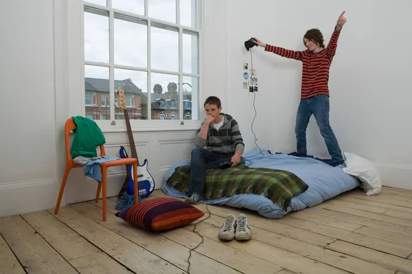 Pojat pelaavat videopelejä sängyssä — kuvapankkivalokuva