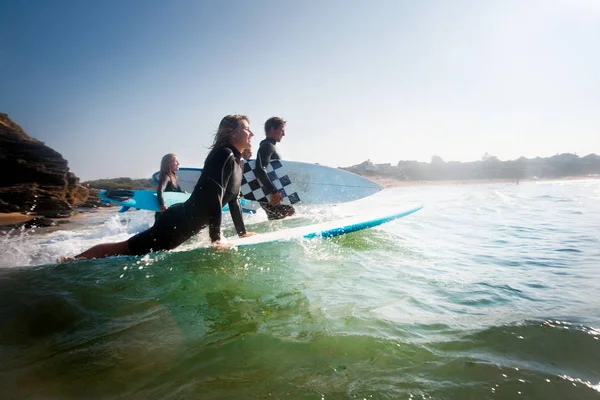 Four people going out to surf — Stock Photo, Image