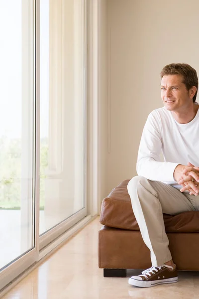 Hombre sentado y mirando por la ventana — Foto de Stock