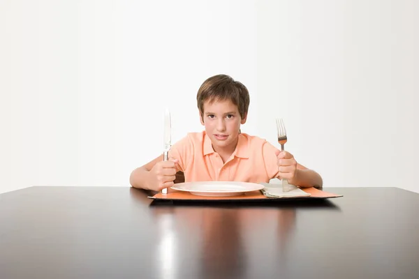 Мальчик сидит за обеденным столом — стоковое фото