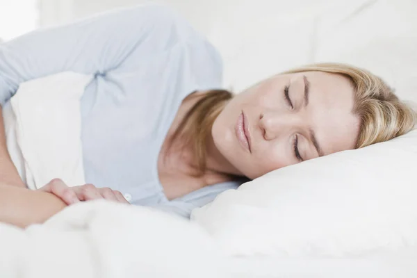 Kvinna sover i sängen — Stockfoto