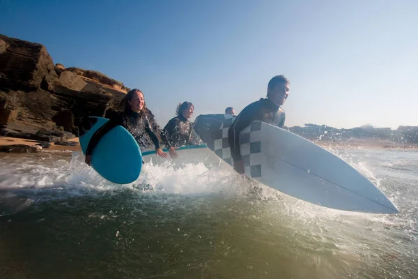 Cuatro personas corriendo hacia el agua —  Fotos de Stock