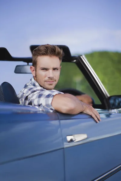 Man peering out of convertible