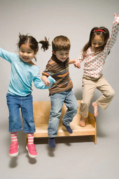 Niños saltando del banco — Foto de Stock