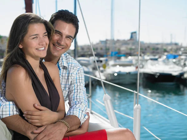 Молодая пара отдыхает на яхте улыбаясь — стоковое фото