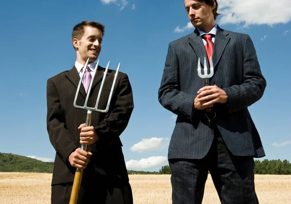 Businessmen holding pitchforks — Stock Photo, Image
