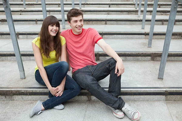 Молодая пара сидит на ступеньках — стоковое фото