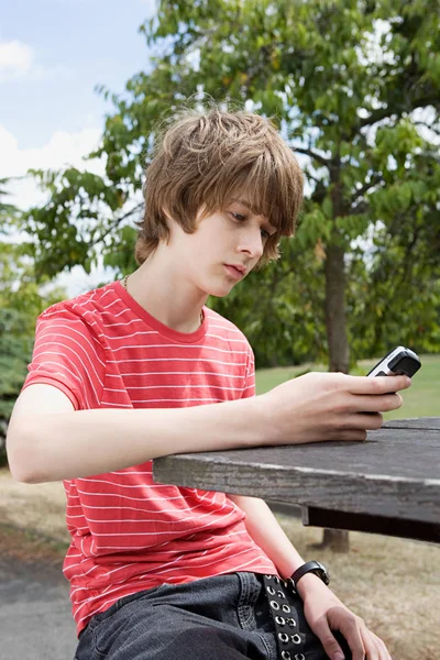 Adolescente niño mirando el teléfono celular — Foto de Stock