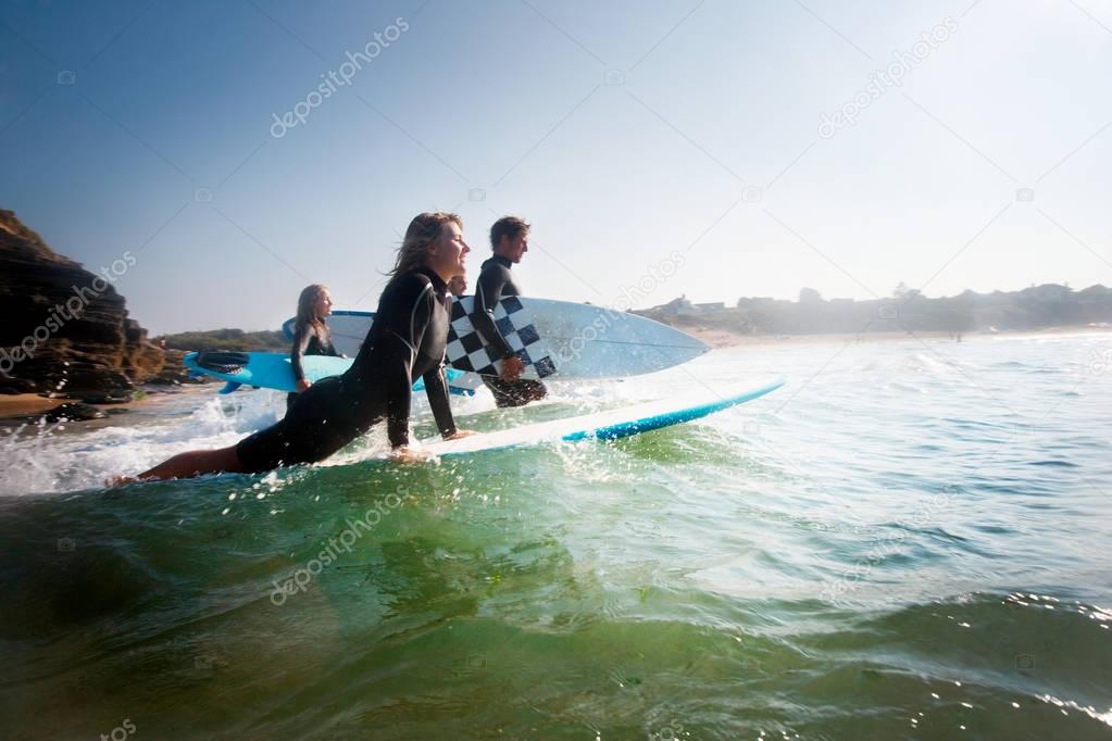 Four people going out to surf