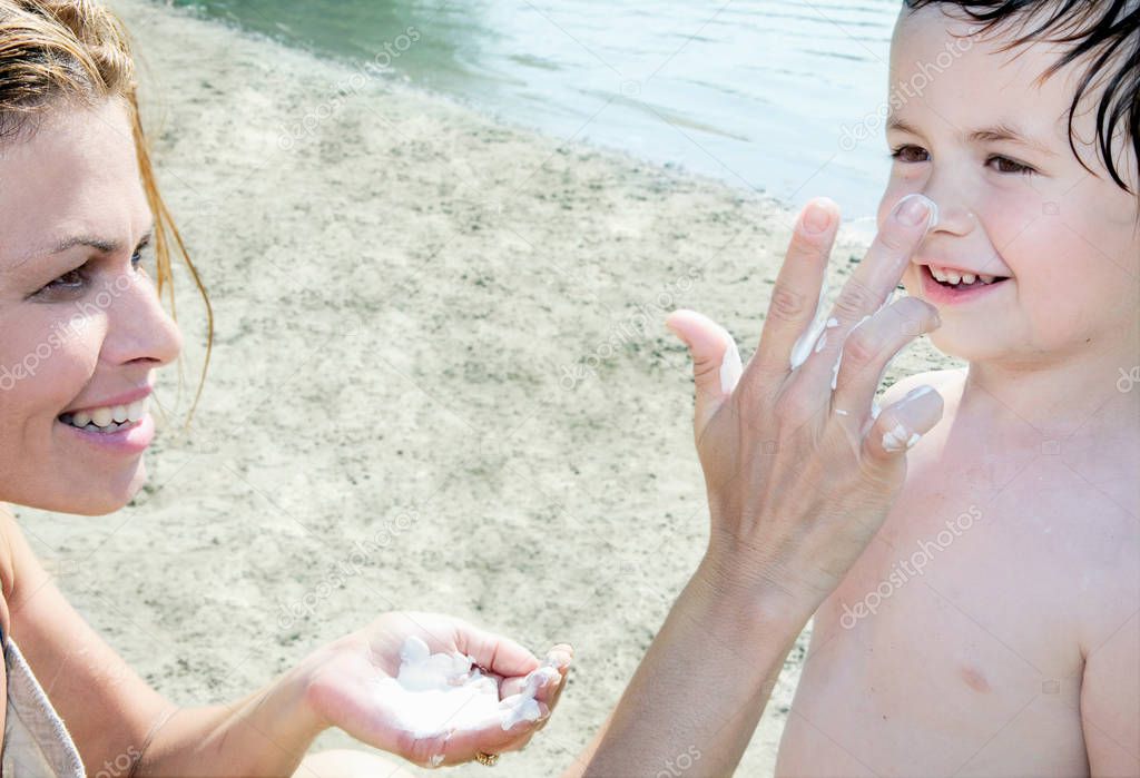 Mother applying sun lotion on Child