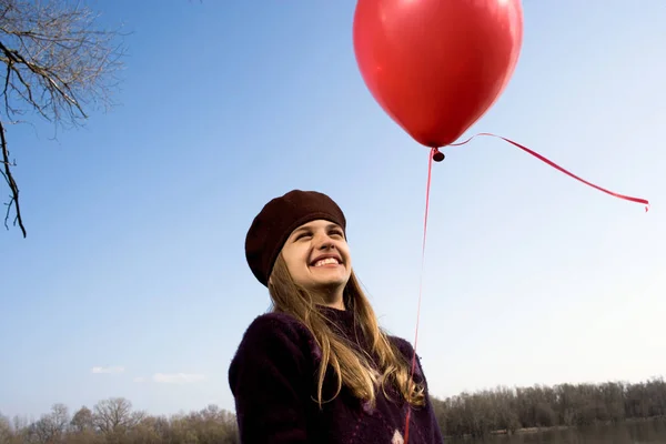 Flicka utomhus anläggning röd ballong — Stockfoto