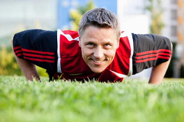 Joueur de football faisant push-ups — Photo