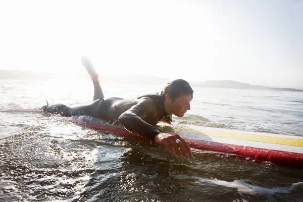 Man lying on surfboard — Stock Photo, Image