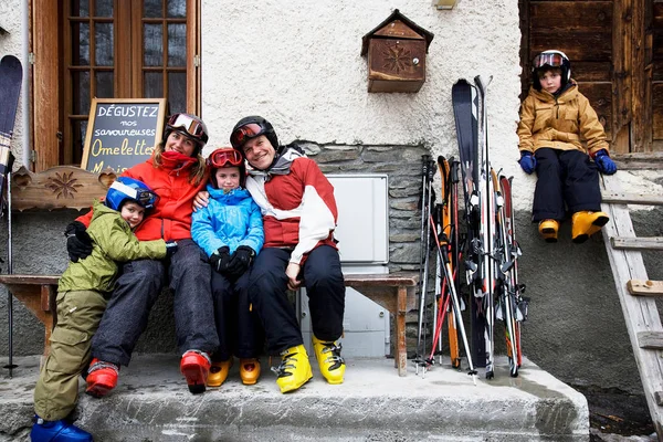 スキーで納屋の外に座っている家族 — ストック写真