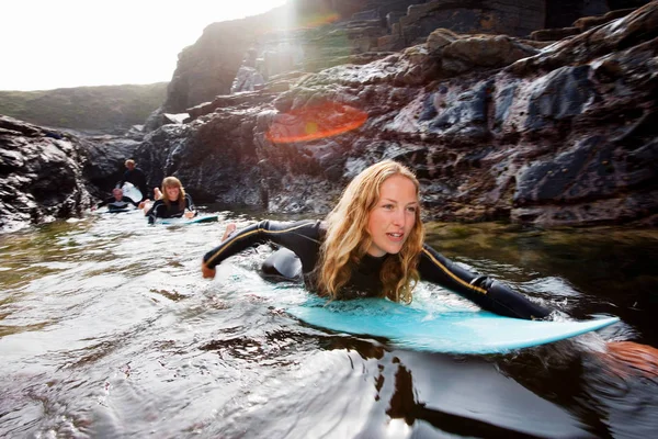 Quatre personnes allongées sur des planches de surf — Photo