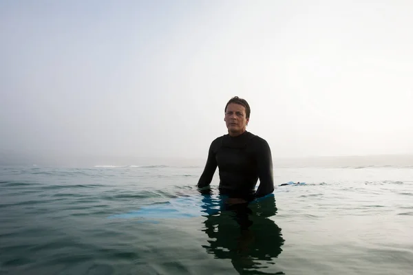 Man sitting on surfboard — Stock Photo, Image