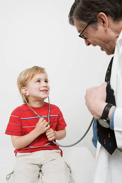 Niño y médico con estetoscopio — Foto de Stock