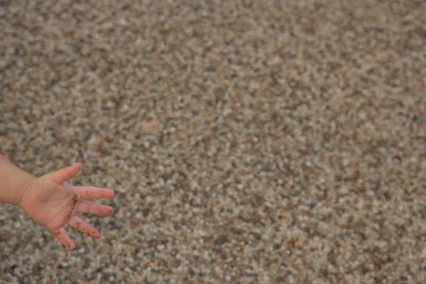 Enfant avec main contre sable — Photo