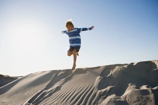 Ragazzo che salta sulla sabbia — Foto Stock