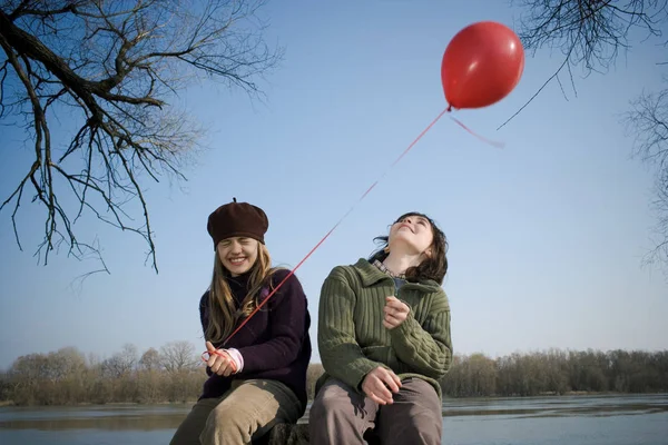 Junge und Mädchen halten Luftballon am Fluss — Stockfoto