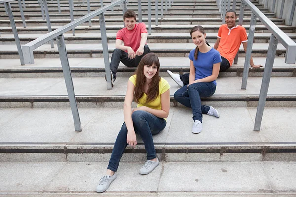 Молодежь, сидящая на ступеньках — стоковое фото