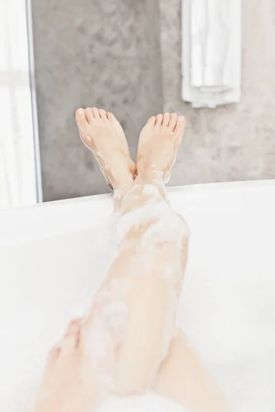 Pernas em banho de espuma — Fotografia de Stock