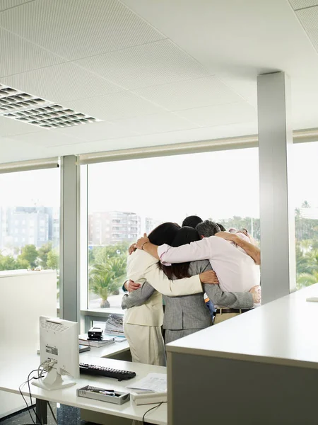 Chers collègues debout dans le huddle dans le bureau — Photo