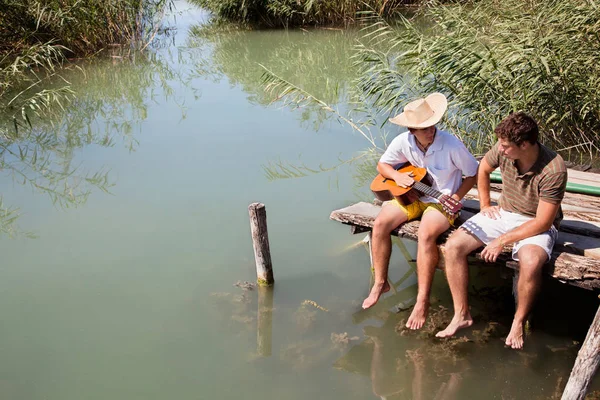 Couple avec guitare relaxant au bord du lac — Photo