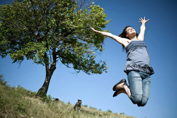Mujer saltando por el árbol — Foto de Stock