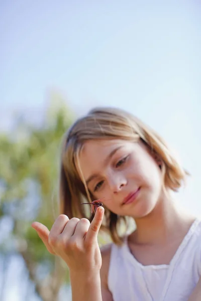 Menina inspecionando libélula — Fotografia de Stock