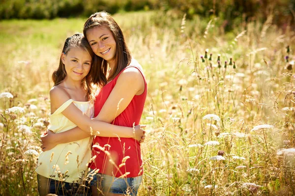 Девушки обнимаются в высокой траве — стоковое фото