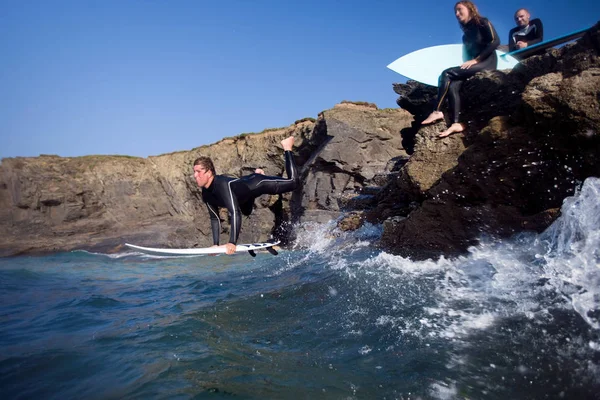 Homme sautant dans l'eau sur la planche de surf — Photo