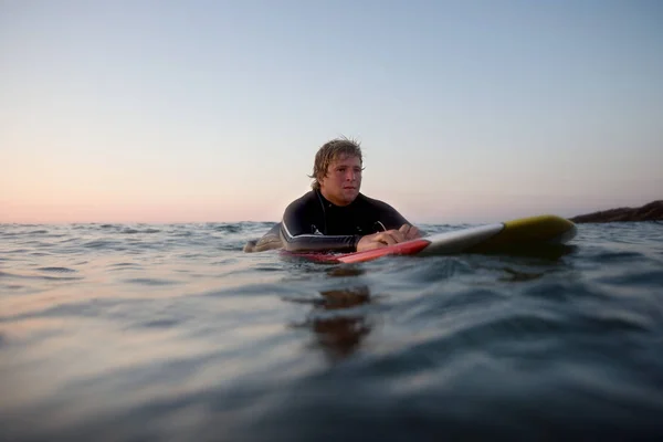 Mann liegt auf Surfbrett — Stockfoto