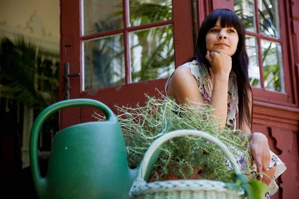 Femme assise avec des plantes — Photo