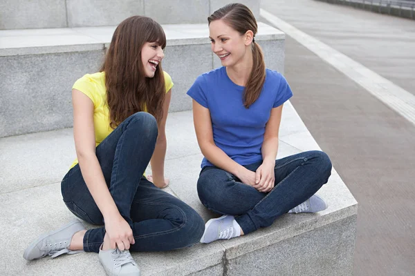 Amigas sentadas fuera de casa — Foto de Stock