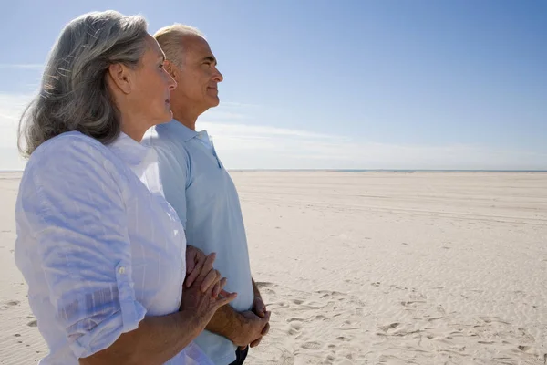 Старший пара стоїть на пляжі — стокове фото