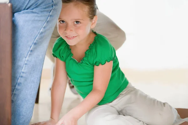 Девушка сидит на взрослых ногах — стоковое фото