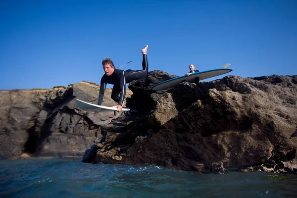 Man jumping onto surfboard — Stock Photo, Image
