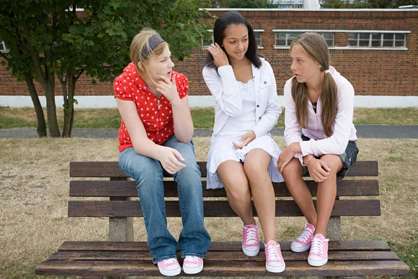 Girls talking on bench — Stock Photo, Image