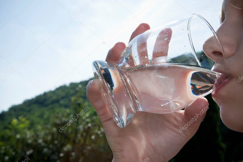 Young girl drinking water close-up