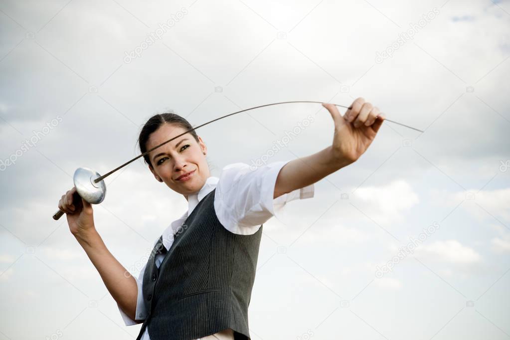 businesswoman with sword against cloudy sky