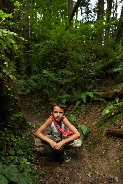 Junge sitzt im Wald auf Hüpfern — Stockfoto