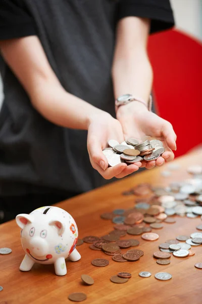 Dívka s prasátko bank drží mince — Stock fotografie