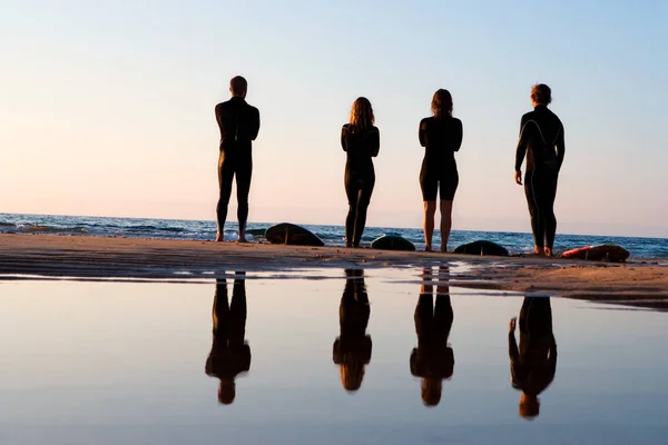 Quatre personnes debout sur la plage — Photo