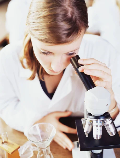 Κορίτσι ψάχνει σε ένα μικροσκόπιο — Φωτογραφία Αρχείου