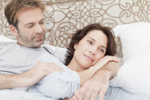 Sonriente pareja relajándose en la cama — Foto de Stock