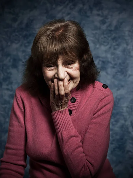 Senior kvinna som täcker leende med hand — Stockfoto